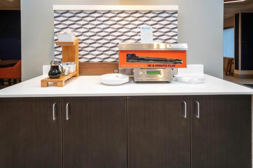 a kitchen counter with a coffee maker on it at Holiday Inn Express and Suites Atlanta-Johns Creek by IHG in Johns Creek