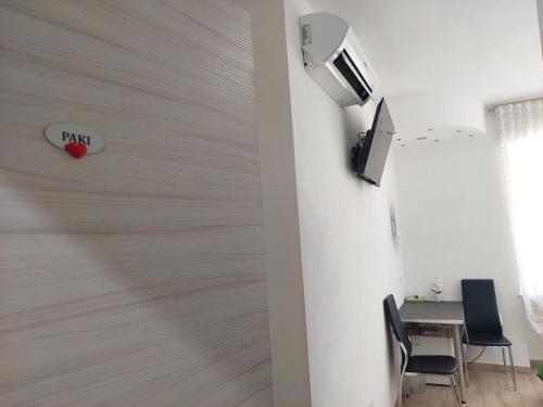 a room with a wall with a tv and a table at Vapama Rooms in Verona