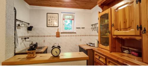 a kitchen with a clock on a wooden counter at Koča Kresnica in Ilirska Bistrica