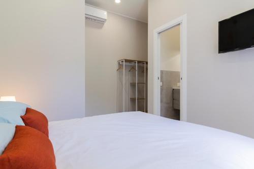 a bedroom with a white bed and a flat screen tv at Aria Marmore in Le Marmore
