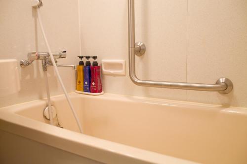 a bathroom with a bath tub with a shower at Tokyo Green Palace in Tokyo