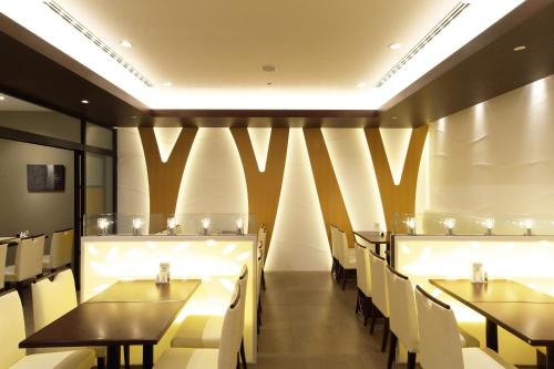 a dining room with tables and white chairs at Tokyo Green Palace in Tokyo