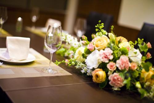 a table with a wine glass and a bouquet of flowers at Tokyo Green Palace in Tokyo