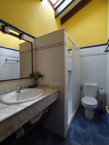 uma casa de banho com um lavatório e um WC em El Acebo em Infiesto