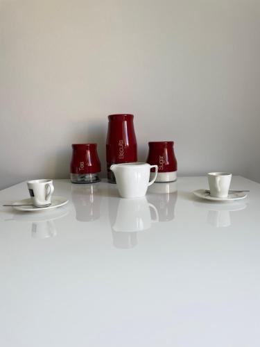 four red cups and saucers on a table at Apartmán V Krátké in Stein Schönau
