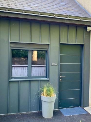 une maison avec deux portes de garage et une plante en pot dans l'établissement Duplex avec parking proche Stade de la Beaujoire, parc des expositions, bord de l'Erdre, à Nantes