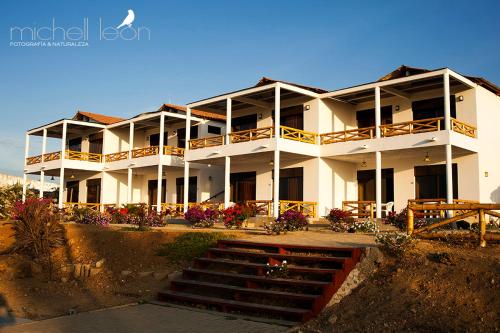 a large white building with stairs in front of it at Amotape Comfort in Zorritos