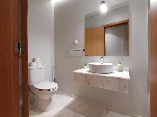 a bathroom with a sink and a toilet and a mirror at Apartments Madeira Funchal City in Funchal