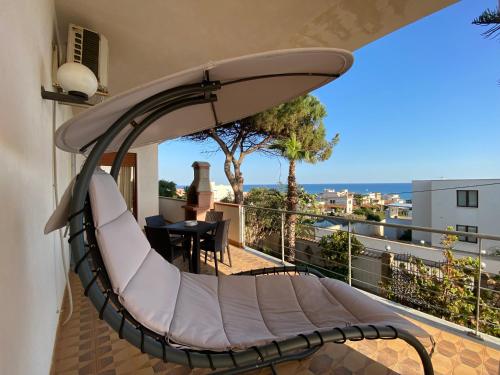 a hammock on a balcony with a surfboard at Sea View - Beautiful Terrace with BBQ in Triscina