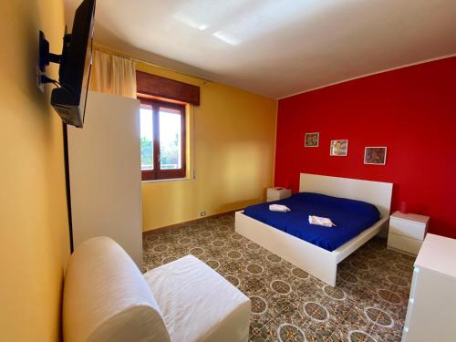 a bedroom with a blue bed and a red wall at Sea View - Beautiful Terrace with BBQ in Triscina