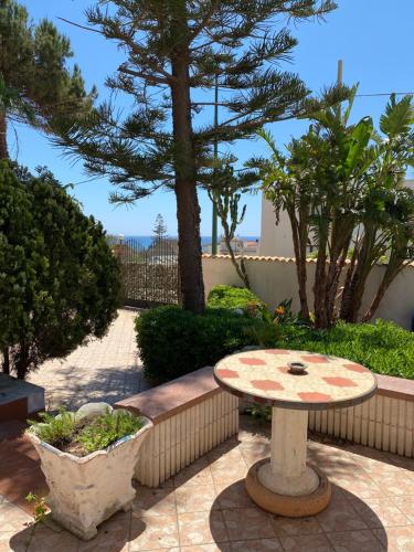 a table in a patio with a view of the beach at Sea View - Beautiful Terrace with BBQ in Triscina