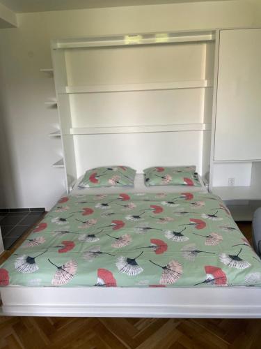 a bed with a green comforter and two pillows at Apartmán V Krátké in Stein Schönau