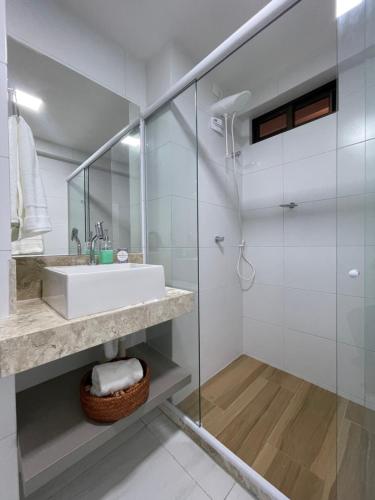 a bathroom with a sink and a glass shower at Mardisa Design by Jess Hospedagens in João Pessoa