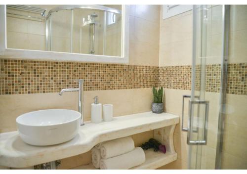 ein Badezimmer mit Waschbecken und Dusche in der Unterkunft SeaScape Mandrakia in Mandrakia