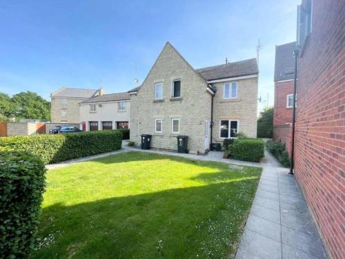 a house with a lawn in front of it at Orchid Cotswold Stone house in Swindon