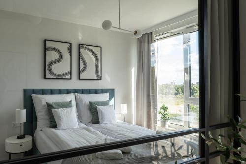 a bedroom with a bed and a large window at Apartament Chlebova 315 in Gdańsk