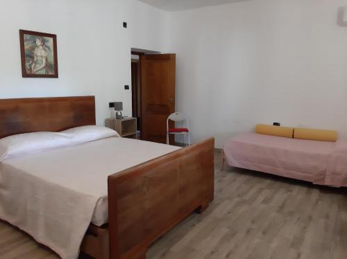 a bedroom with two beds and a chair in it at Guesthouse da Caterina in San Giovanni