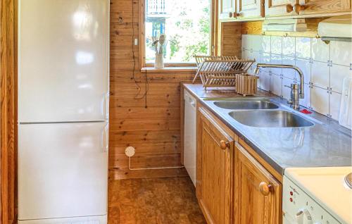 a kitchen with a white refrigerator and a sink at Gorgeous Home In Ludvika With Sauna in Ludvika