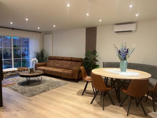 a living room with a table and a couch at Vakantiewoning De Winning in Houthalen-Helchteren