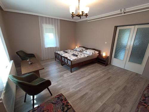 - une chambre avec un lit, une table et des chaises dans l'établissement Anna Vendégház, à Balatonfenyves