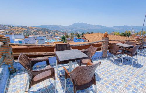 a patio with tables and chairs on a roof at Riad Mauritania in Chefchaouen