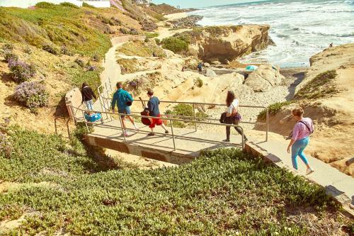 a group of people walking down a staircase to the beach at Samesun Ocean Beach Hotel & Hostel in San Diego