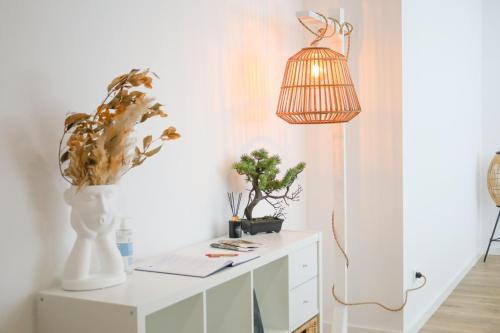 a white cabinet with a lamp and a plant on it at Pinheiro Guest House in Ponte de Lima
