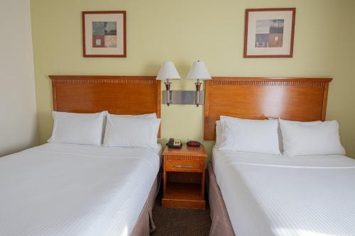 a hotel room with two beds and a night stand at Candlewood Suites New Iberia by IHG in New Iberia