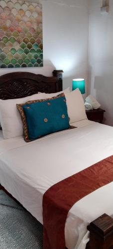 a bedroom with a large white bed with a blue pillow at Lajuela BnB & Hostel in Alajuela City
