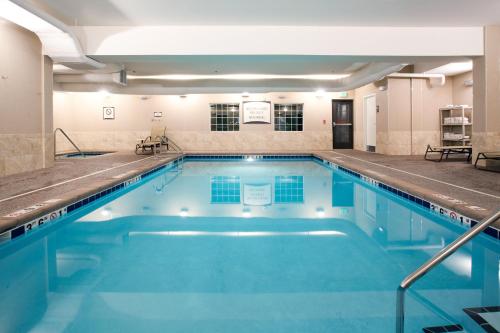 a swimming pool with blue water in a building at Staybridge Suites Great Falls by IHG in Great Falls