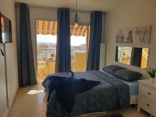 1 dormitorio con cama y ventana grande en Preciosas habitaciones en la casa de May en Arona