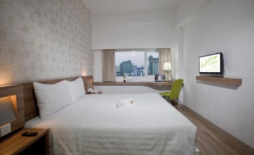 Ένα ή περισσότερα κρεβάτια σε δωμάτιο στο Whiz Hotel Cikini Jakarta