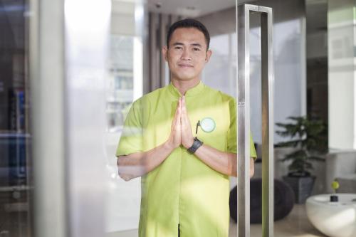a man standing in a room with his hands at Whiz Hotel Cikini Jakarta in Jakarta