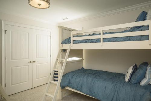 a bedroom with two bunk beds and a ladder at The Anchor Holds by Oak Island Accommodations in Oak Island