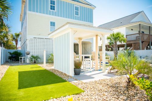 a white house with a lawn in front of it at The Anchor Holds by Oak Island Accommodations in Oak Island