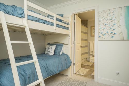 a bedroom with two bunk beds and a bedroom backdoor at The Anchor Holds by Oak Island Accommodations in Oak Island