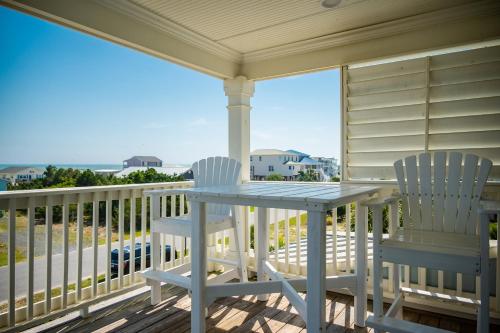 a porch with two chairs and a table on a balcony at The Anchor Holds by Oak Island Accommodations in Oak Island