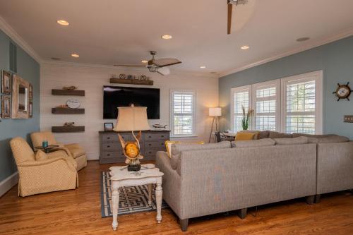 a living room with two couches and a tv at The Anchor Holds by Oak Island Accommodations in Oak Island