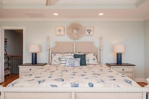 a bedroom with a large white bed with blue flowers at The Anchor Holds by Oak Island Accommodations in Oak Island