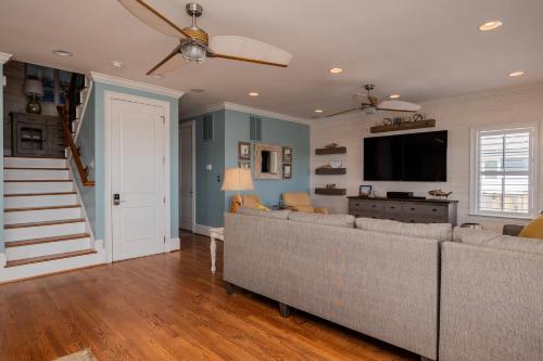 a living room with a couch and a flat screen tv at The Anchor Holds by Oak Island Accommodations in Oak Island
