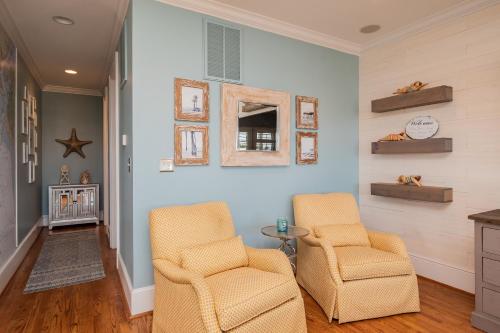 two chairs and a table in a living room at The Anchor Holds by Oak Island Accommodations in Oak Island