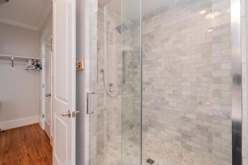 a bathroom with a shower with a glass door at The Anchor Holds by Oak Island Accommodations in Oak Island
