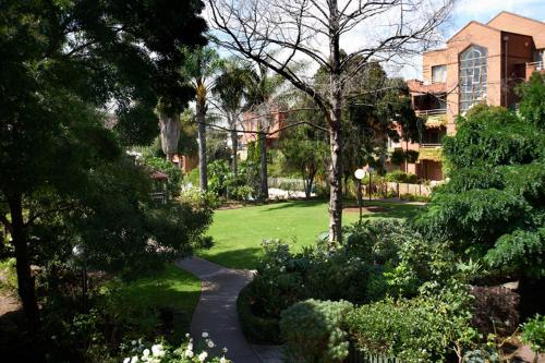 a garden with a walkway in front of a building at Comfort Apartments Royal Gardens in Melbourne