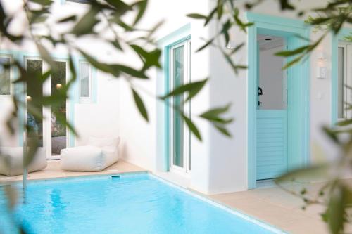a swimming pool in a house with a blue door at Majo Suites Hotel in Agia Anna Naxos