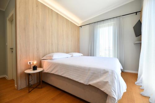 a bedroom with a large bed with a candle on a table at Villa Abyss in Zadar