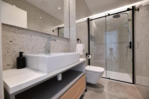 a bathroom with a sink and a shower and a toilet at Villa Abyss in Zadar