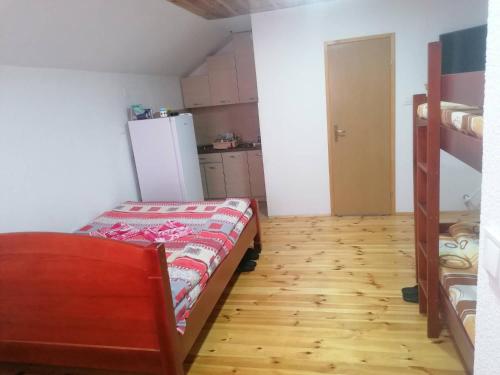 a small room with a bed and a refrigerator at Guesthouse Wolf in Žabljak
