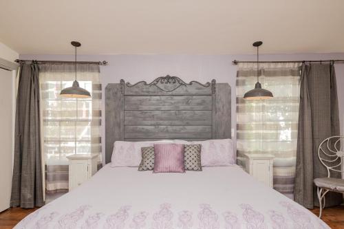 ein Schlafzimmer mit einem großen weißen Bett mit rosa Kissen in der Unterkunft Candy Store House by Oak Island Accommodations in Southport