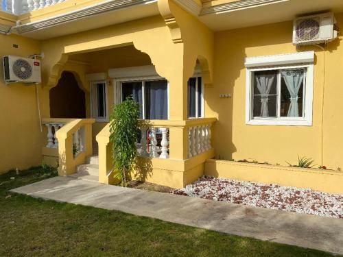 a yellow house with a plant in the window at Lovely 2 Bedroom Apartment in Quiet Neighborhood! in Philipsburg