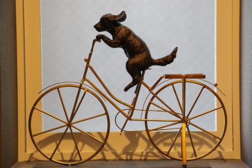 a statue of a dog riding a bike at Private house Kuranoya Sapporo in Sapporo